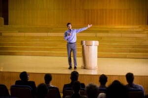 Keynote speaker presenting on stage at a UK tech conference in London.